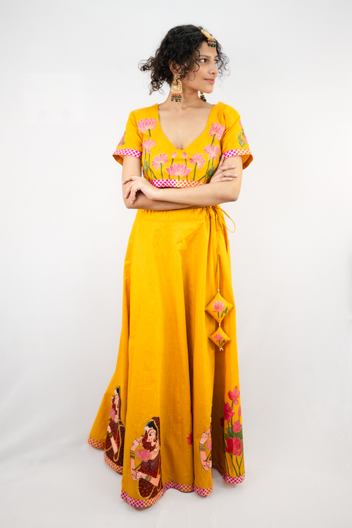 pure hand-woven cotton lehenga set. Embalished with Handpainting of women in maroon saree and pink lotus with leaves.
